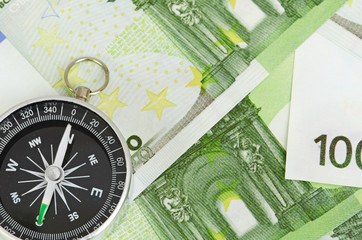 euro bank notes and a compass