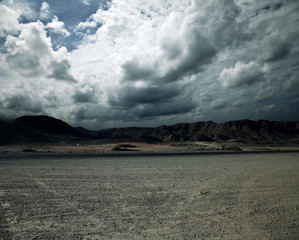 Road in field and stormy clouds