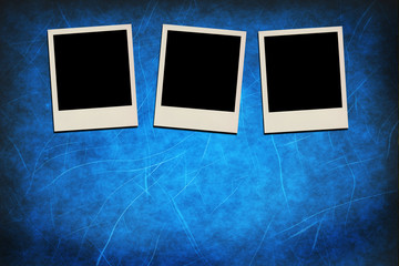 Blank instant photo frames on grunge blue background