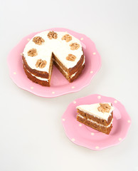 carrot cake with cream cheese frosting in a pink on white