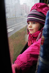Zamyślona dziewczynka jedzie tramwajem