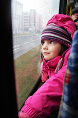 Zapatrzona dziewczynka jedzie tramwajem - obrazy, fototapety, plakaty