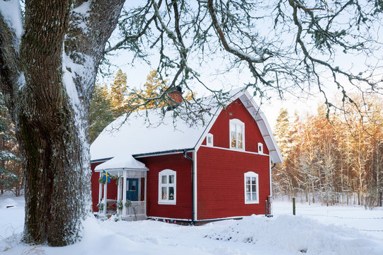 Rotes Holzhaus im winterlichen Schweden