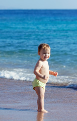 Happy toddler  on sand beach