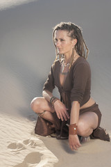 Sexy Middle Aged Cougar Woman crouching in the sand dune. 