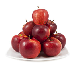 Red apples on a white plate isolated on white