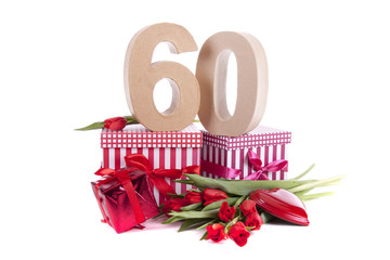 Age in figures in a party mood on a bed of red tulips