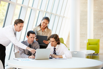 Businesspeople Having Meeting Around Table In Modern Office