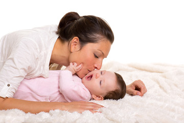 Baby girl and mother lying happy playing together