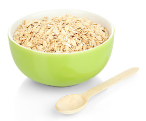 Green bowl full of oat flakes with wooden spoon isolated