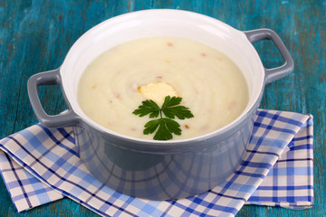 Mashed potatoes in saucepan on blue wooden table