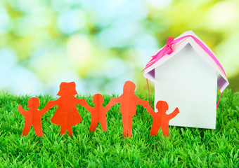 Paper people on green grass on bright background