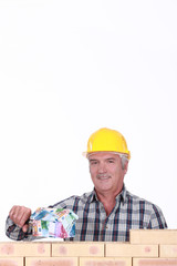 Builder with a house made of money