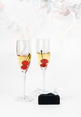 Two Valentine's champagne glasses with jewelery on white