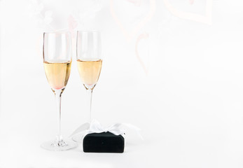 Two Valentine's champagne glasses with jewelery on white