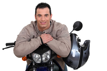 Man on a motorbike with his helmet on the side