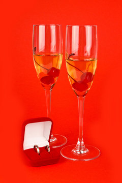 Two Valentine's champagne glasses with jewelery on red