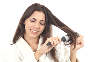 Fototapeta premium Woman suffering combing with the hairbrush