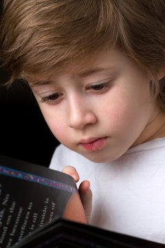 Cute little boy reading a book