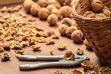 Fototapeta na wymiar Closeup of cracking walnuts on wicker basket