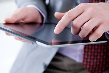 Male hands touching digital tablet