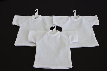 White t-shirts with coat hanger isolated on black background