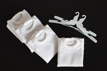White t-shirts with coat hanger isolated on black background