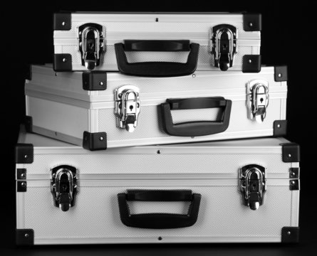 Silvery suitcases on black background