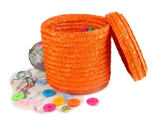 Orange wicker basket with accessories for needlework isolated