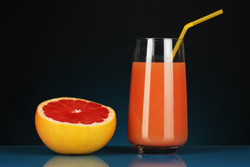 Obraz na płótnie Canvas Pyszny sok grejpfrutowy w szkle i grejpfruta obok