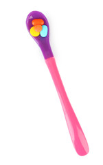 Plastic spoon with color pills, isolated on white