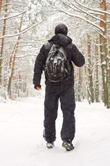Fototapeta na wymiar The man walking in winter forest