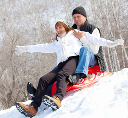 Mature couple sledding