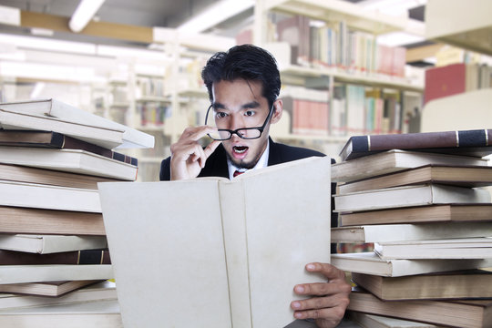 Businessman on shock looking at books