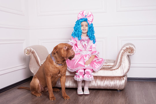 Cute girl dressed like Malvina with dog posing on sofa