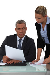 Fototapeta premium Boss showing paperwork to assistant