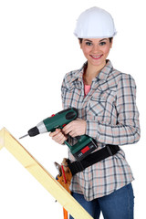 Woman drilling into plank of wood