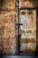Rusty old brown metal door with a lock