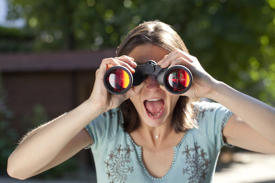 amazed woman looking through binoculars