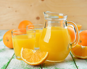 Fototapeta na wymiar Sok pomarańczowy w naczyniu na białym tabeli