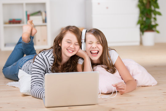 zwei freundinnen hören musik mit laptop