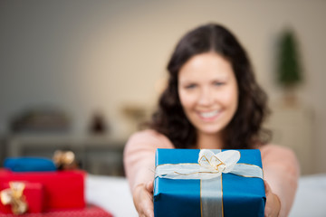 lächelnde frau überreicht ein weihnachtsgeschenk