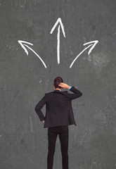 confused business man thinking wich way to go