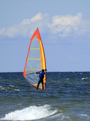 Windsurfer on the blue sea surface .