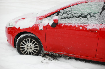 Red snow covered car in winter