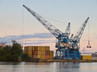 Two cranes are waiting for cargo in a dutch harbour