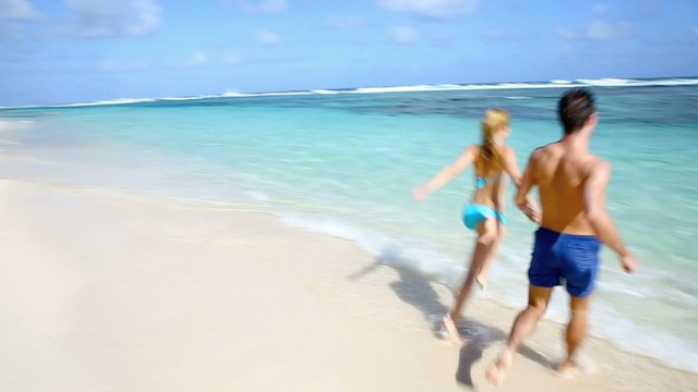 Couple running on sandy beach in caribbean island