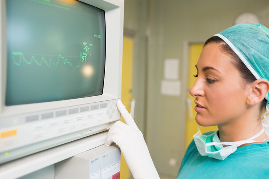 Smiling female surgeon standing next to a monitor - Powered by Adobe