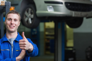 Auto mechanic gesturing thumbs up