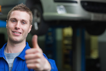 Smart car mechanic gesturing thumbs up